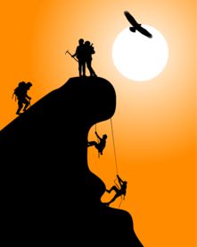 阳光下站在峰顶的攀岩运动员