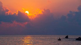 海边石头日落晚霞太阳倒影