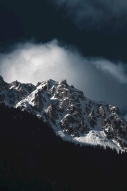 白色乌云下的雪山山峰