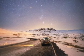 星空下雪山路上的汽车