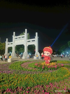 夜晚花坛旁的中式牌坊景观