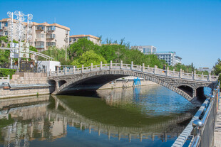 河畔石桥映蓝天绿树
