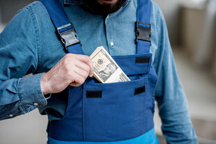 工人从工作服中拿出钞票