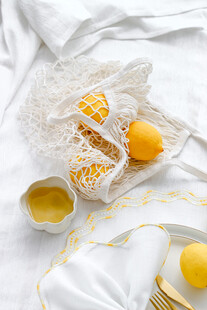 网兜中的鲜黄柠檬与布