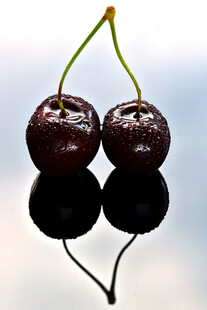 双颗紫樱桃及其倒影