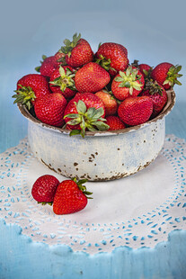 碗中鲜草莓摆于蕾丝布上