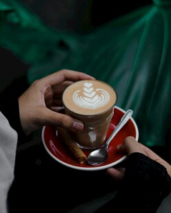 手持精美拉花咖啡杯