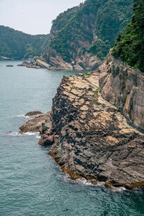 海岸边嶙峋岩石与青山