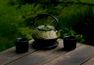 户外木桌上的茶壶与茶杯