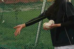 女子手持垒球准备投掷