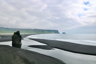 黑沙滩边的孤独身影