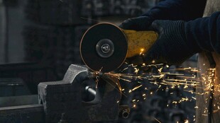 工人操作磨具火花四溅