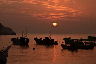 夕阳下的海港渔船景象