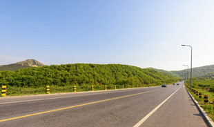 宽阔公路旁的葱郁青山