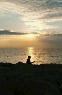 夕阳下的海边独钓者