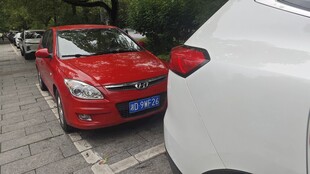 路边停放的红色与白色轿车