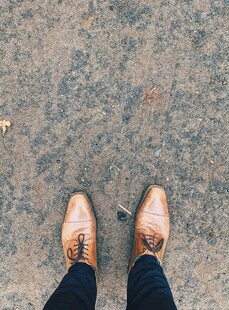 棕色皮鞋下的地面视角