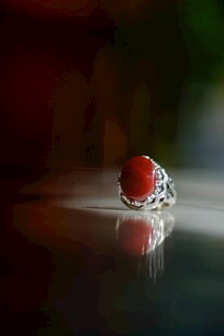 晶莹红珠静置于反光面