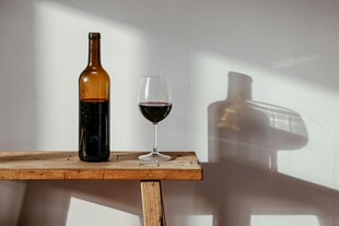 木桌上的红酒瓶与酒杯