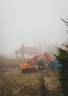 雾中施工的挖掘机与建筑