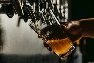 手持啤酒杯接新鲜啤酒