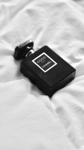 黑色香水瓶置于白色布面