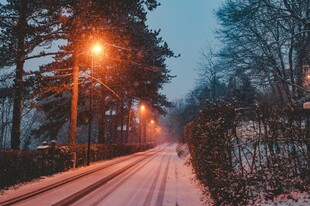 雪夜林间小路暖灯相伴