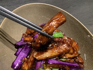 筷子夹起美味茄子炒肉