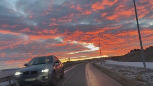 公路上夕阳下行驶的汽车