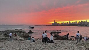 夕阳下沙滩上的休闲人群