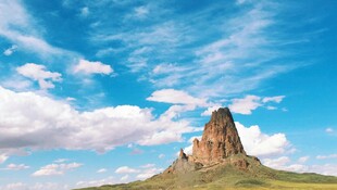 孤峰矗立蓝天白云间