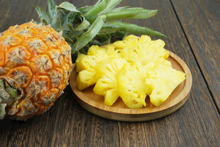 新鲜菠萝切块摆于木盘