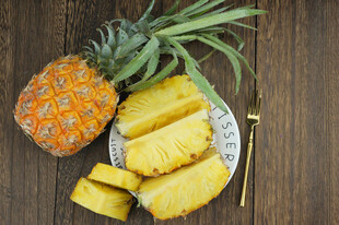 新鲜菠萝切片摆放在木桌