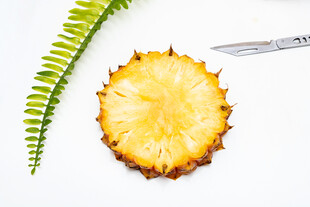 切开的菠萝与绿植和刀具