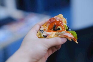 手拿美味披萨一角