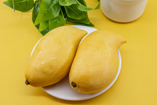 两个金黄芒果置于白盘