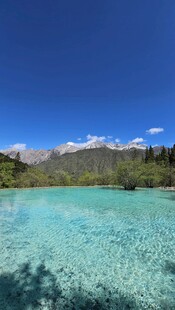 清澈蓝湖与远处山峦美景