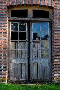 老旧木门立于砖墙前