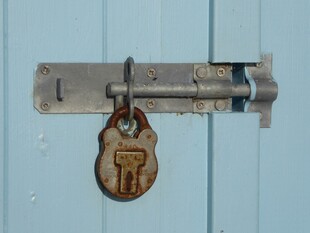 复古挂锁挂于蓝色门栓上