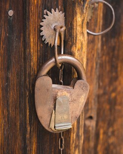 复古铜锁挂于斑驳木门上