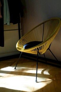 阳光中的黄色藤编休闲椅