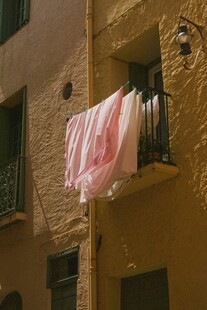 窗边晾晒的粉色床单