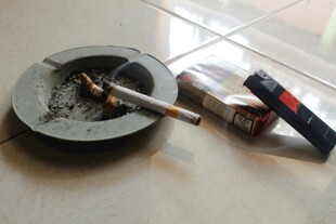 烟灰缸旁的香烟与打火机