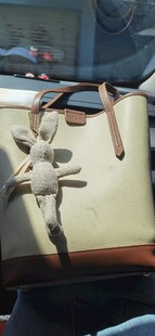 可爱玩偶挂在时尚包包上