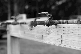 老旧水龙头置于砖墙边