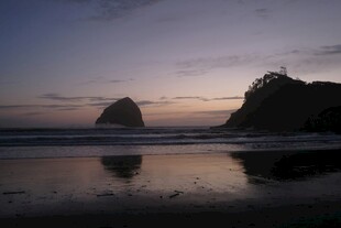 黄昏海滨孤岩映于浅滩