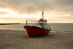 夕阳下搁浅的红白船只