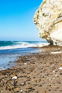 海边嶙峋岩石下的沙滩