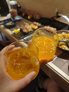 手持橙饮享丰盛美食时刻