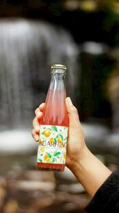 手持缤纷果汁瓶于自然间